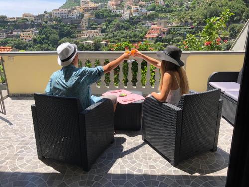 un homme et une femme assis à une table sur un balcon dans l'établissement Casa Tutti Frutti, à Positano