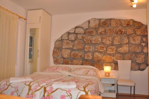 um quarto com uma cama e uma parede de pedra em Apartments Lucic em Dubrovnik