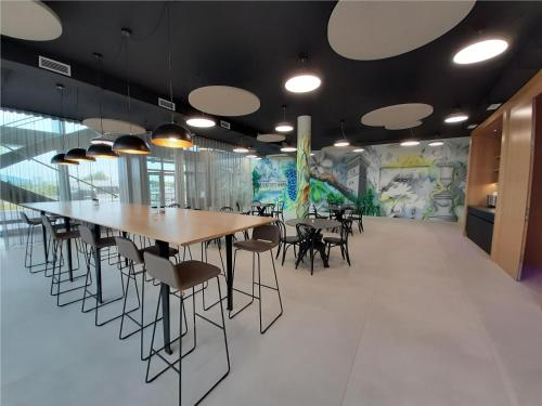 a dining room with tables and chairs and a mural at Office Base Bad Vöslau MOTEL in Bad Vöslau