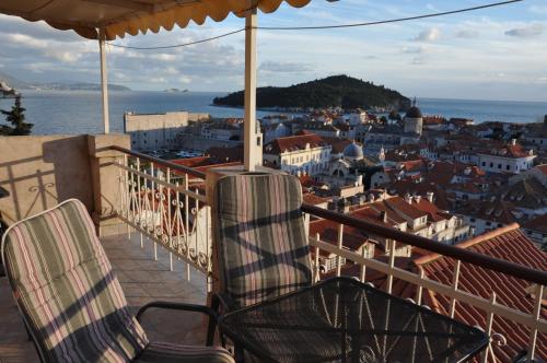 Duas cadeiras sentadas numa varanda com vista para uma cidade em Apartments Lucic em Dubrovnik