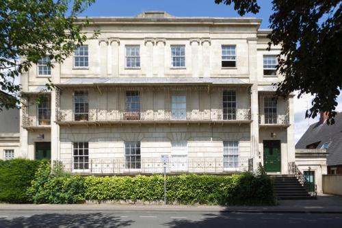 um grande edifício branco com uma porta verde em Judges Lodgings Hotel Apartments Gloucester Docks with Secure Parking em Gloucester