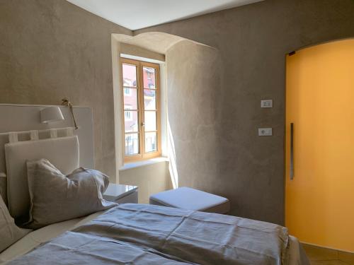 een slaapkamer met een bed, een raam en een toilet bij Rennweg 114 in Merano