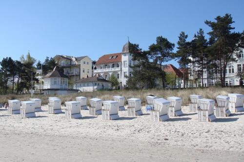 rząd białych krzeseł na plaży w obiekcie Strandhotel zur Promenade w mieście Binz