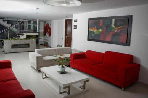 a living room with two red couches and a table at Zi One Luxury Hotel in Pereira