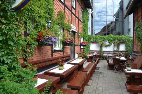 - un patio avec des bancs en bois et des fleurs dans un bâtiment dans l'établissement Alex Maja, à Pärnu