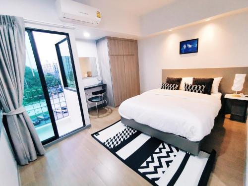 - une chambre avec un lit et une grande fenêtre dans l'établissement Star Sukhumvit, à Bangkok