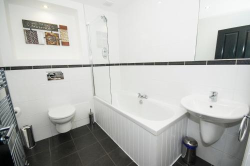 Baño blanco con lavabo y aseo en Parkhill Luxury Serviced Apartments - City Centre Apartments, en Aberdeen