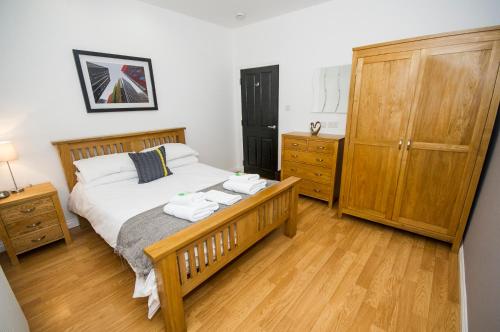 1 dormitorio con 1 cama con 2 toallas en Parkhill Luxury Serviced Apartments - City Centre Apartments, en Aberdeen