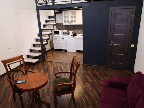 een woonkamer met een tafel en stoelen en een trap bij Затишні апартаменти, вулиця Дерибасівська, 13 in Odessa