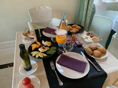 una mesa con platos de comida y una botella de zumo de naranja en Hotel Boutique Edelweiss La Garriga, en La Garriga