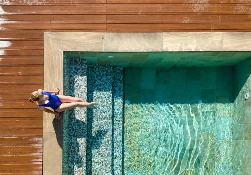 Eine Frau schwimmt im Pool in der Unterkunft Hotel Resort & Spa Miramonti in Rota d'Imagna