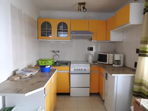 a kitchen with orange cabinets and a white stove top oven at Haus Gizella in Harkány