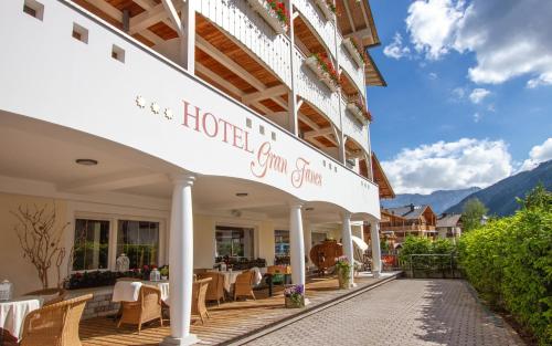 un hotel con tavoli e sedie su un patio di Hotel Gran Fanes a Corvara in Badia