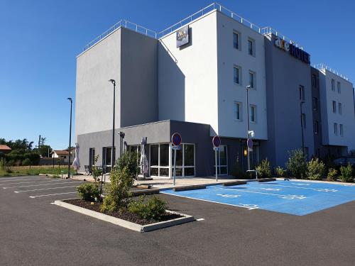 a building with a basketball court in a parking lot at Ace Hôtel Toulouse Blagnac in Cornebarrieu