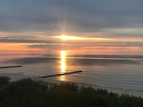 un tramonto sull'acqua con il tramonto di Apartament Słoneczny przy plaży a Dziwnówek