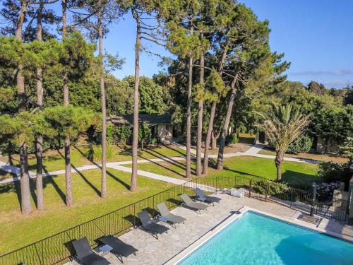 une piscine avec des chaises, une clôture et des arbres dans l'établissement Prea Gianca, à Bonifacio