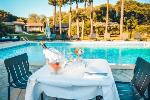 - une table avec une bouteille de vin à côté de la piscine dans l'établissement Prea Gianca, à Bonifacio