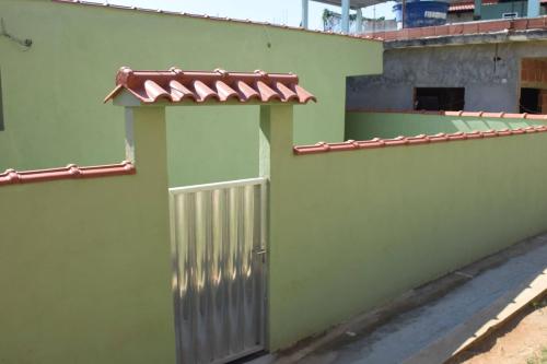 a green building with a gate and a roof at Carvalho de Paquetá in Rio de Janeiro