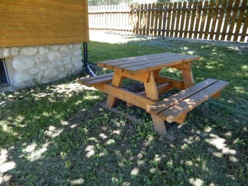 - une table de pique-nique en bois et un banc dans l'herbe dans l'établissement Chata Dolný Smokovec Správa TANAPu, à Dolný Smokovec