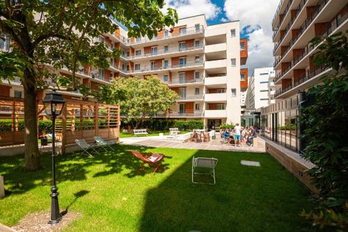 un patio con césped frente a un edificio en Hostel Le Hüb Grenoble, en Grenoble