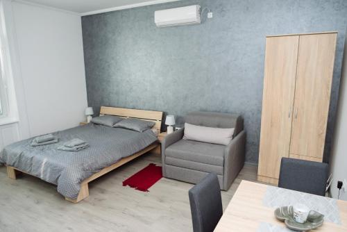 1 dormitorio con 1 cama y 1 silla en D&D apartments, en Subotica