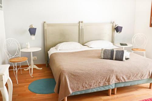 a bedroom with a large bed with two tables and chairs at A La Villa Boucicaut in Chalon-sur-Saône