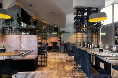 um restaurante com mesas e cadeiras e um bar em Hotel Cool Zagreb Airport em Velika Gorica