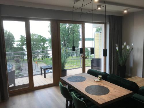 ein Esszimmer mit einem Tisch und grünen Stühlen in der Unterkunft Marina Green Loft-Apartament przy promenadzie in Lyck