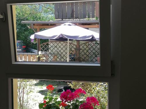 uma janela com vista para uma mesa com um guarda-chuva em Jogis Ferienwohnungen em Freiburg im Breisgau