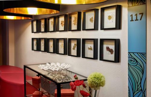 a wall with a bunch of framed pictures on it at centra Hotel in Schwedt