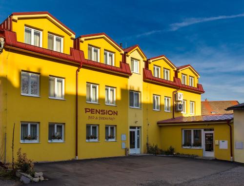 a yellow building with a sign on the side of it at Pension Bed&Breakfast in Kutná Hora