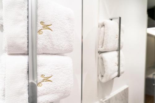 a stack of white towels in a bathroom at Hôtel Merveilleux Côté Mer in Dunkerque