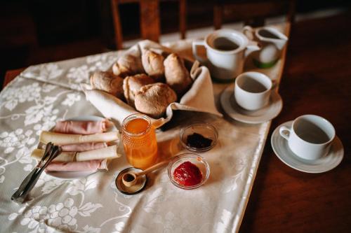 una mesa con una bandeja de pan y tazas de café en Casas de Pedra - Quinta da Escola, en Alvados