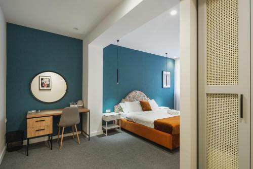 een slaapkamer met een bed, een bureau en een spiegel bij Hotel Bohemian Garni - Skadarlija in Belgrado