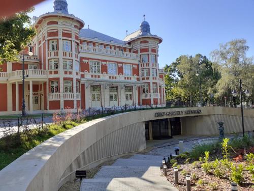 un grand bâtiment avec un pont en face dans l'établissement HEMNES Apartman, à Kaposvár