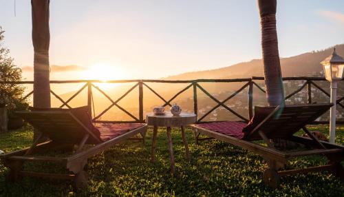 een tafel en stoelen met uitzicht op de oceaan bij Casa dos Avos in Calheta