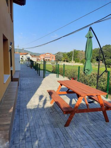 einen Picknicktisch und einen Regenschirm auf einer Terrasse in der Unterkunft EL CINCHO - LA COLINA in Arnuero