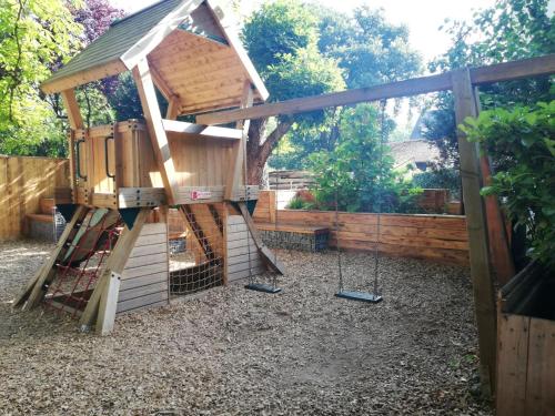 a tree house with a ladder and swings at Blesius Garten in Trier