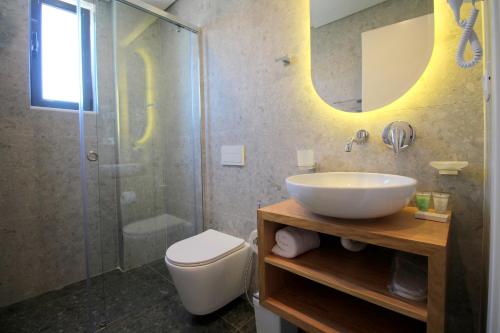 a bathroom with a sink and a shower and a toilet at Blue Eye Hotel in Ksamil