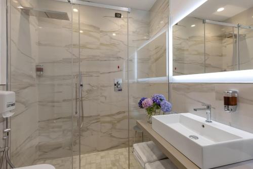 a bathroom with a sink and a shower at Hotel Ancora in Verbania