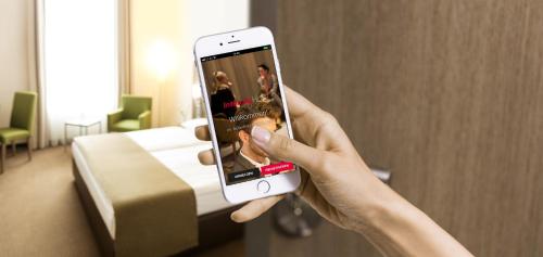 a person taking a picture of a hotel room with their cell phone at IntercityHotel Mainz in Mainz