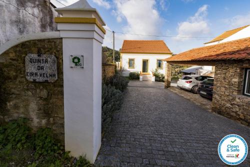 een bord op een muur naast een stenen weg bij Quinta da Eira Velha in Aldeia do Mato