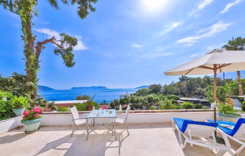 une terrasse avec une table, des chaises et un parasol dans l'établissement Gardenia Hotel, à Kaş