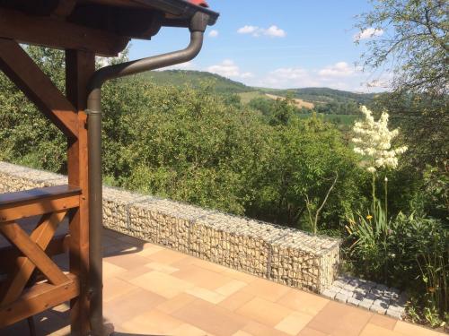 una vista dal balcone di una casa con un muro in pietra di Ferienwohnung Saaletalblick a Jena