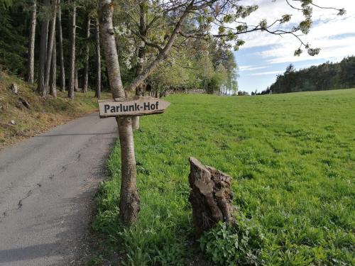 un cartello su un albero vicino a una strada di Parlunkhof a Castelrotto