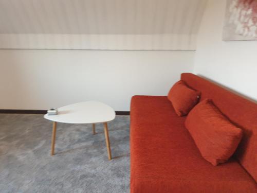 un sofá rojo y una mesa en una habitación en Ferienwohnung Möwenblick, en Flensburg