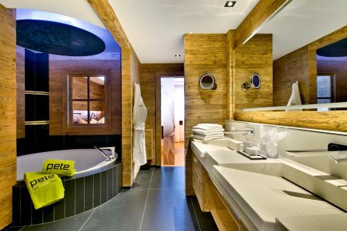 y baño con 3 lavabos, bañera y bañera. en PETE Alpine Boutique Hotel - klein und fein - Private SPA Suiten und Zimmer, en Sankt Anton am Arlberg