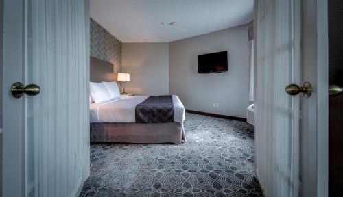 a hotel room with a bed and a television at Monte Carlo Inn Markham in Markham