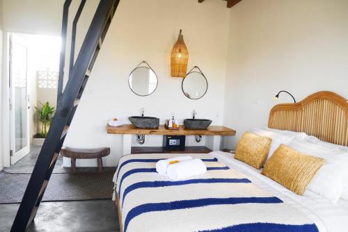 Schlafzimmer mit einem Bett mit Spiegeln an der Wand in der Unterkunft Amar Boutique Hotel in Canggu