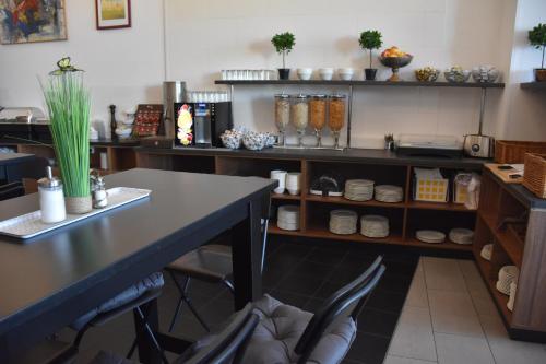 a kitchen with a table and chairs in a room at HB1 Budget Hotel - contactless check in in Wiener Neudorf